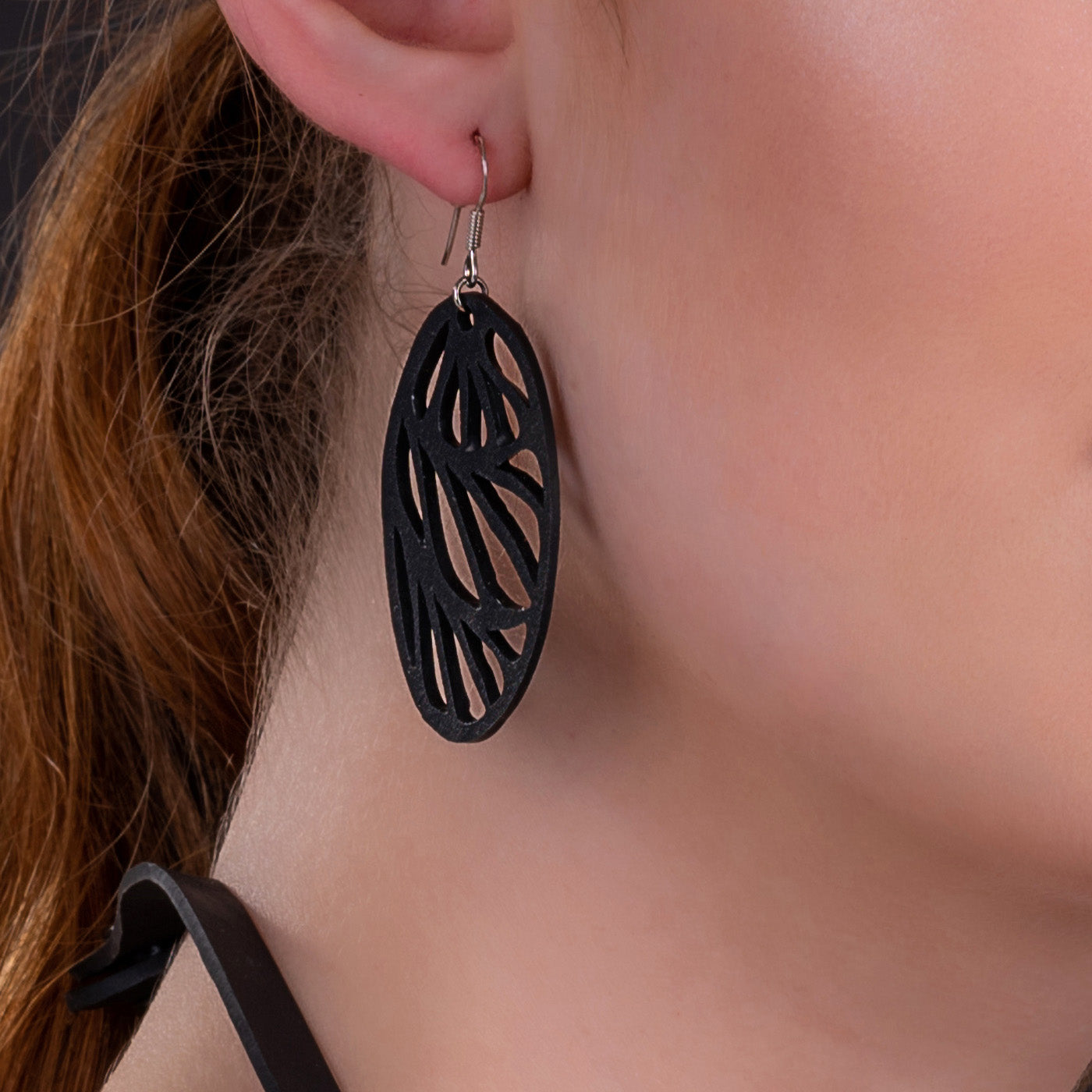 Paguro Upcycle black oval filigree dangle recycled rubber earrings on model ear lightweight sustainable design