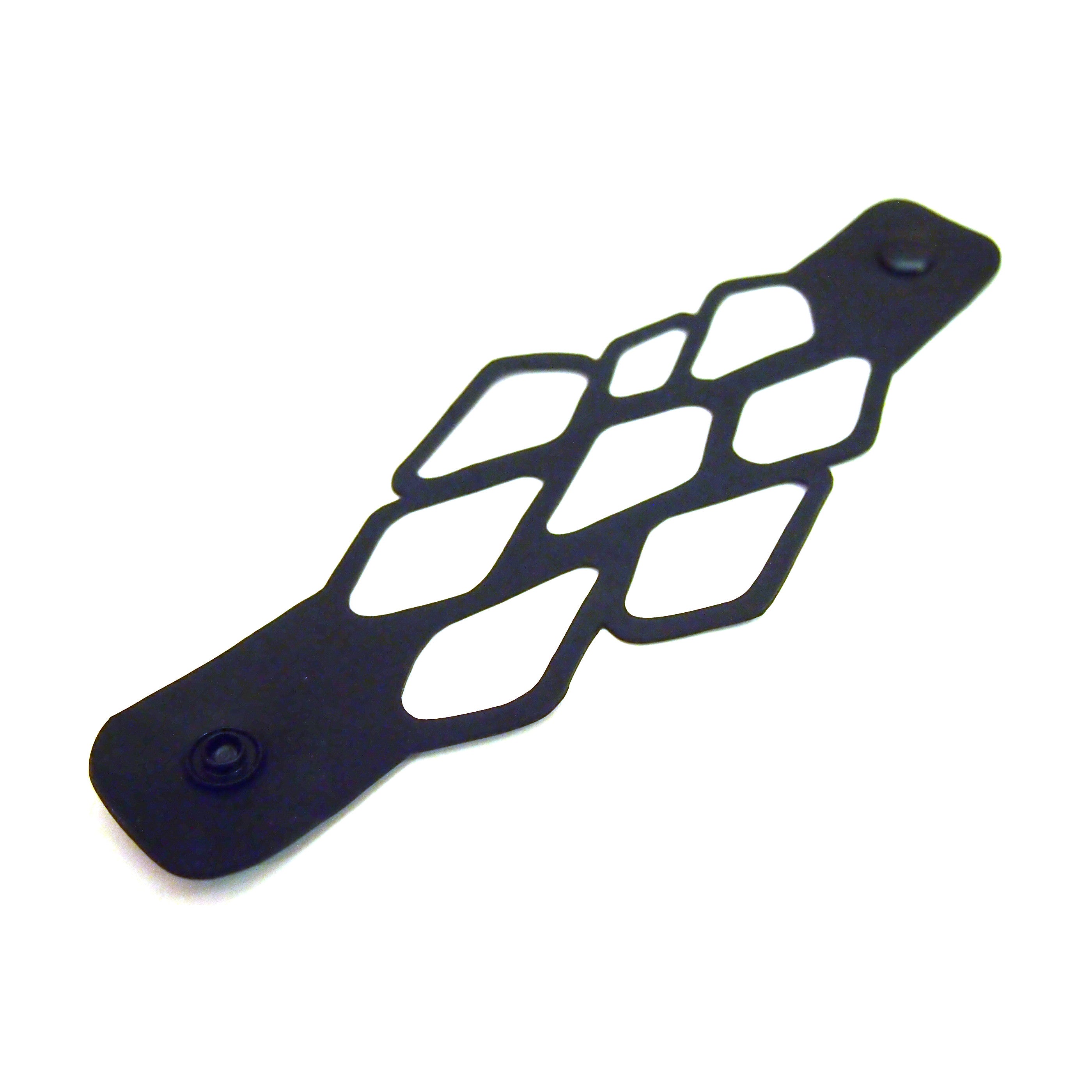 Black recycled rubber bracelet by Paguro Upcycle with geometric cutout design and snap closures