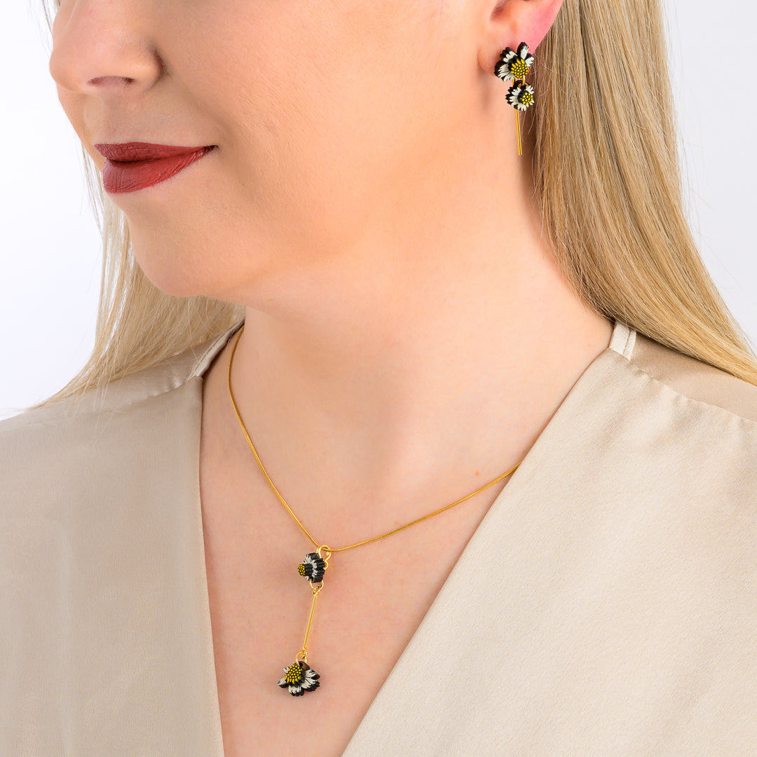 Paguro Upcycle reclaimed wood earrings with black and yellow floral design worn by woman