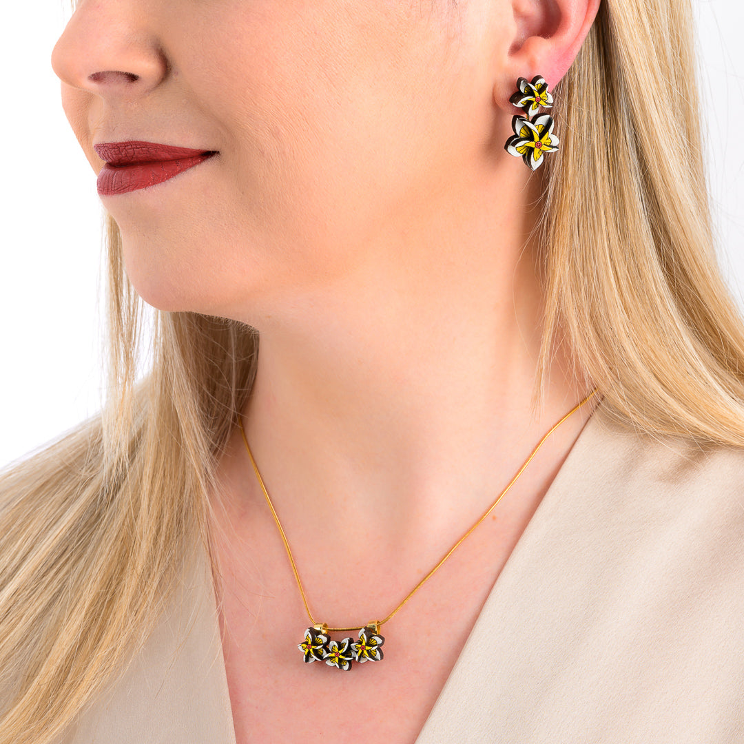 Paguro Upcycle floral reclaimed wood earrings worn by woman with matching necklace set