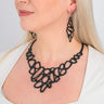 Paguro Upcycle black recycled rubber earrings with matching necklace worn by woman