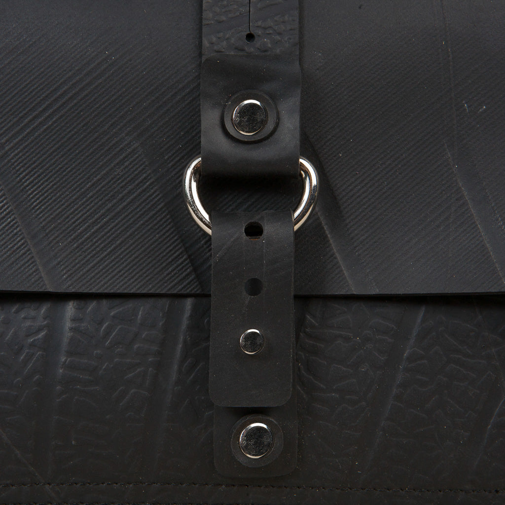 Close-up detail of black vegan handbag strap and metal button by Paguro Upcycle