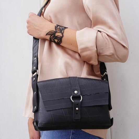 Black vegan handbag by Paguro Upcycle worn crossbody with buckle detail and adjustable strap