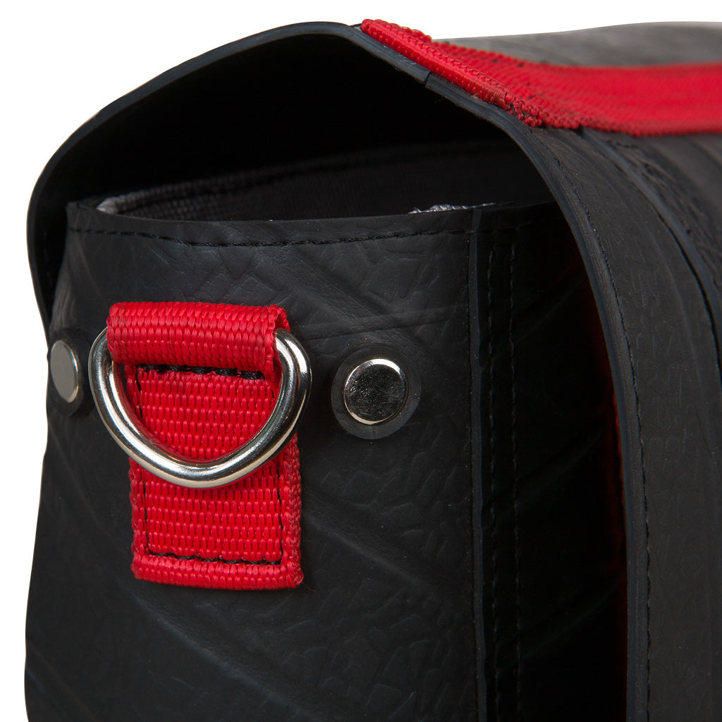 Close-up of recycled rubber messenger bag with red strap and metal ring by Paguro Upcycle