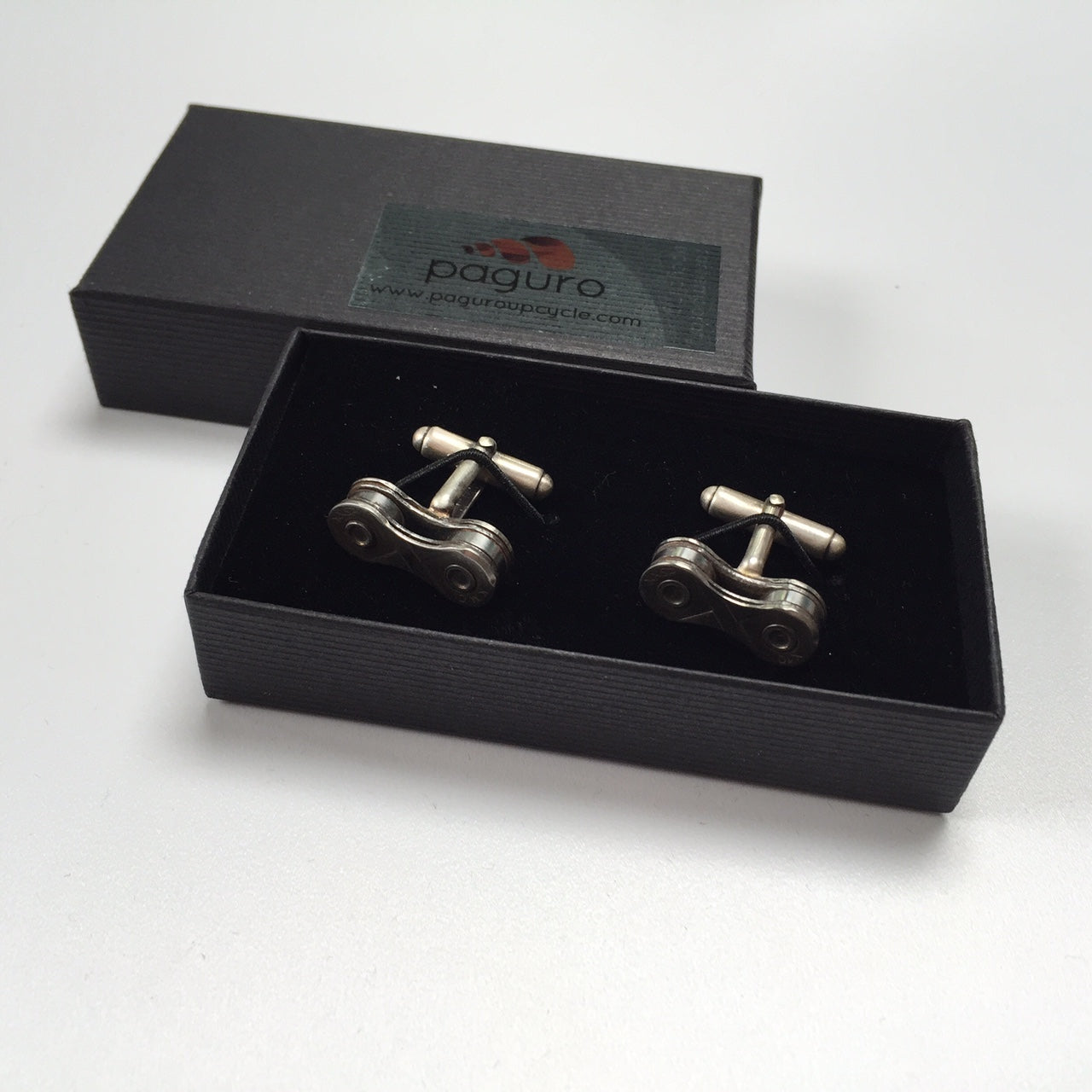 Paguro Upcycle recycled bicycle chain cufflinks displayed in a black gift box