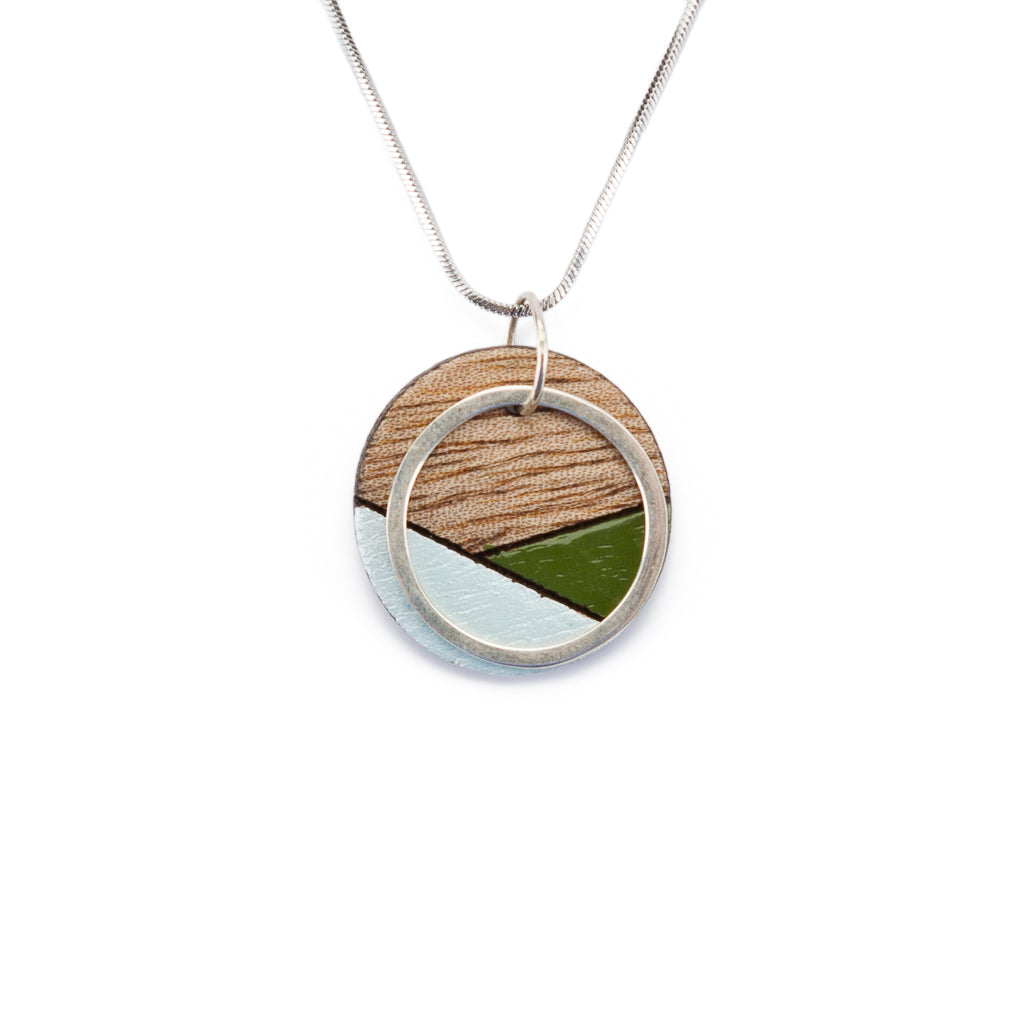 Paguro Upcycle recycled wood silver necklace with circular pendant featuring wood, silver, and green accents