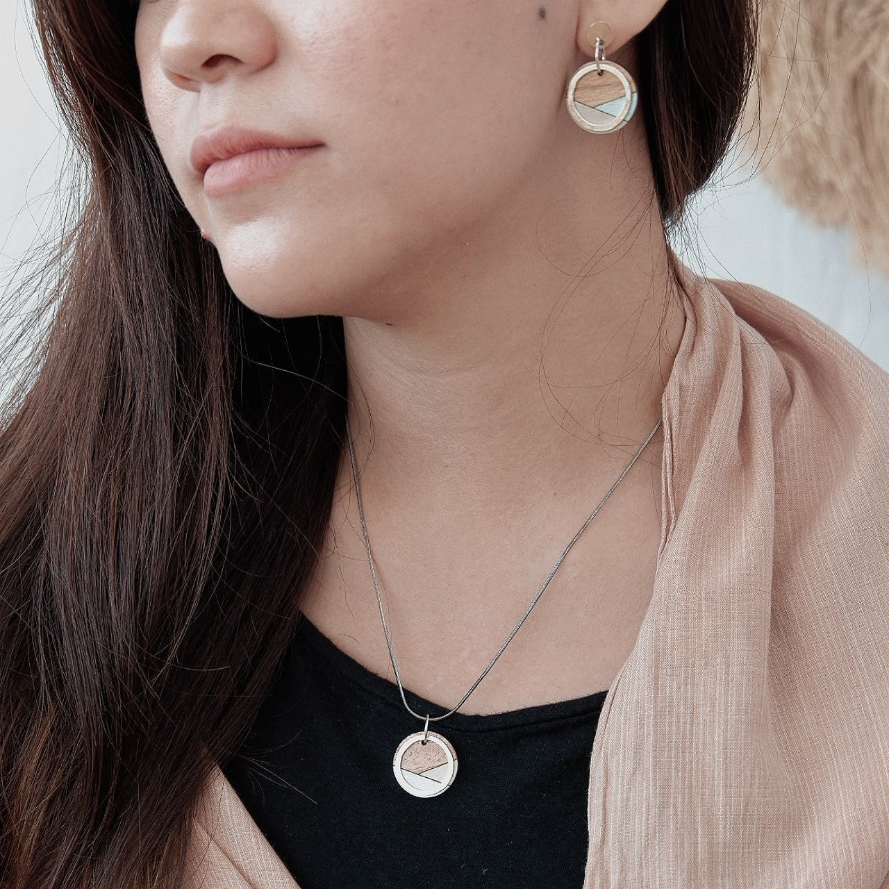 Paguro Upcycle recycled wood silver necklace worn with matching earrings on woman