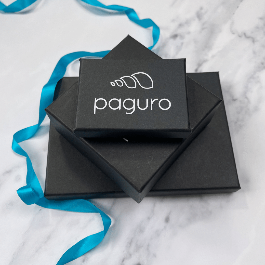 Paguro Upcycle black jewelry boxes stacked with blue ribbon on marble surface for recycled wood silver necklace