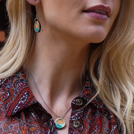 Paguro Upcycle recycled wood silver necklace worn by woman with blonde hair and patterned shirt