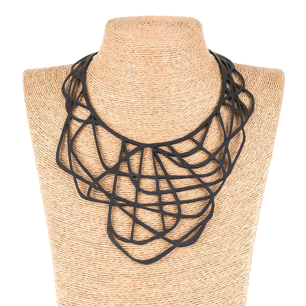 Paguro Upcycle black upcycled rubber necklace with intricate geometric design on display bust