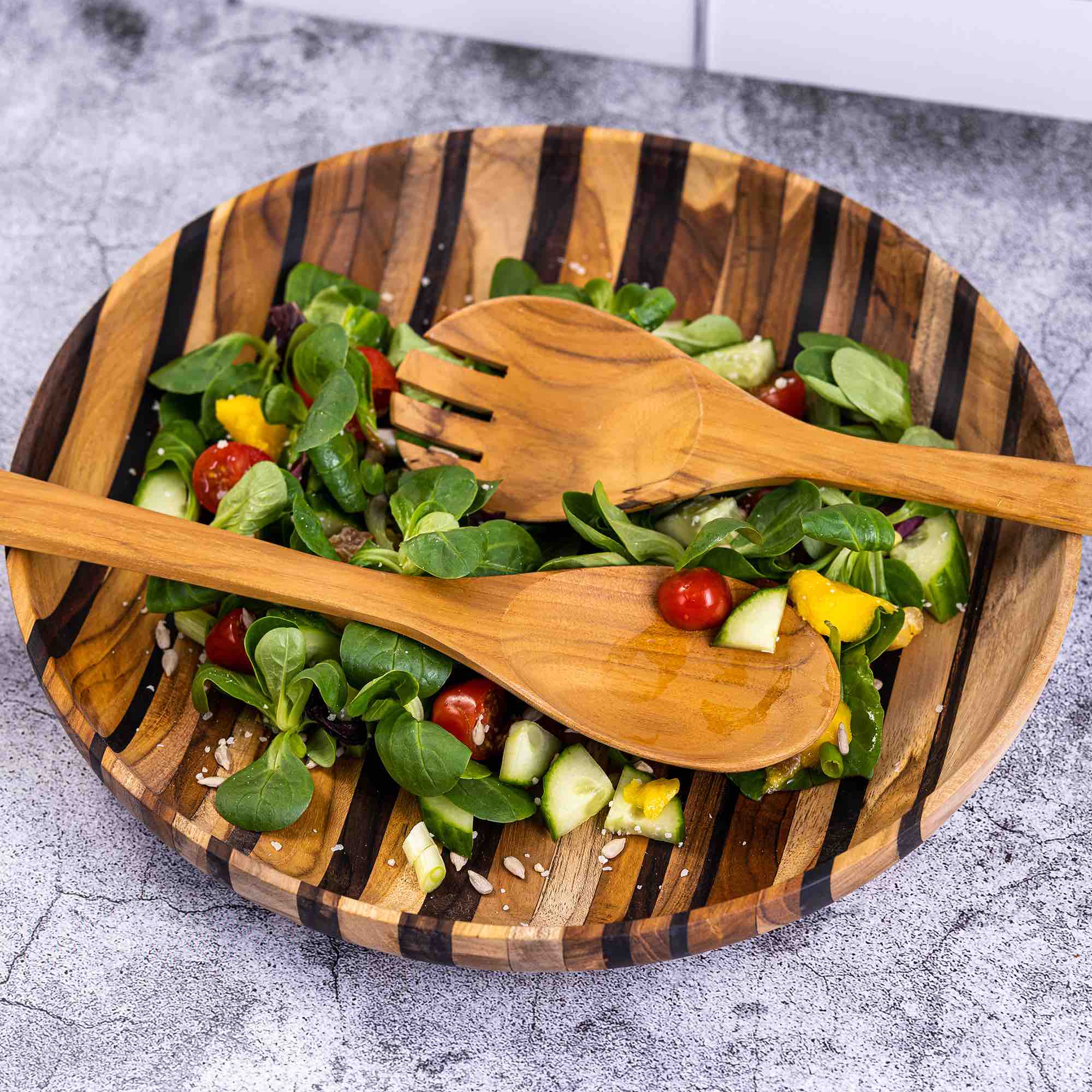 Paguro Upcycle upcycled wooden salad servers spoon and fork on wooden salad bowl with fresh mixed greens