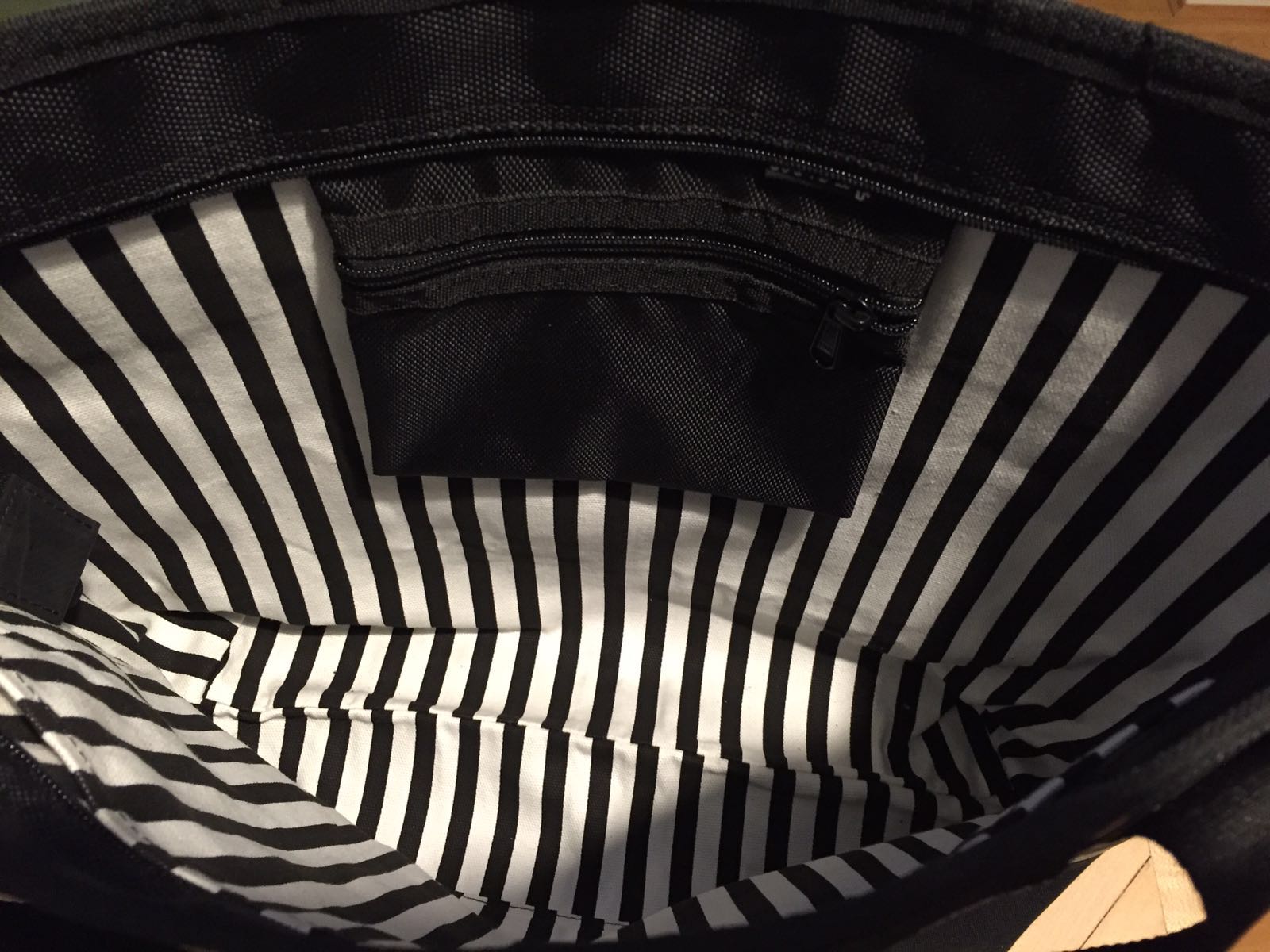 Interior view of vegan tote bag made from inner tube showing black and white striped lining with zipper pocket