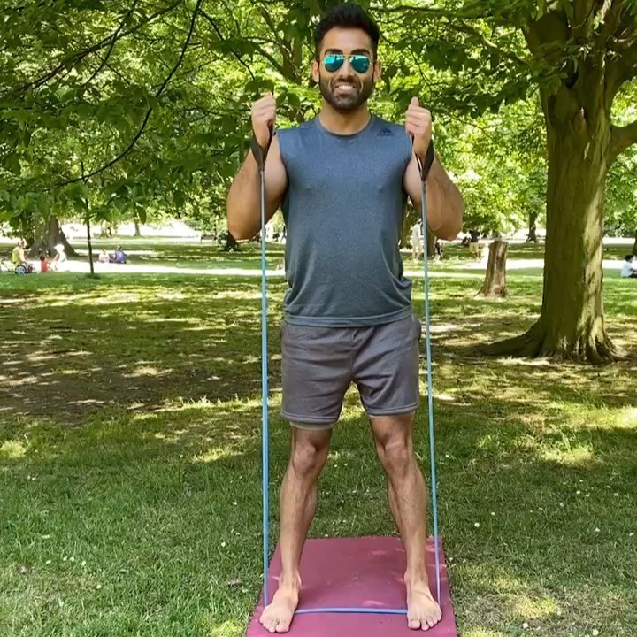 Man exercising outdoors using a blue upcycled resistance band from Paguro Upcycle on a yoga mat